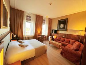 a hotel room with a bed and a couch at Hotel Dordrecht in Dordrecht