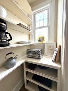 a kitchen with white shelves and a window at The Bushnell Suite C2 in Hartford