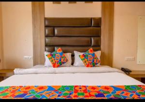a bedroom with a large bed with colorful pillows at As Residency in Dehradun