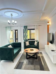 a living room with a green couch and a coffee table at Residence Life House Makepe bm in Douala