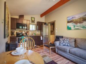 a kitchen and a living room with a couch and a table at Explorer's Retreat Sauna & Bunkhouse & Fire pit in Port Renfrew