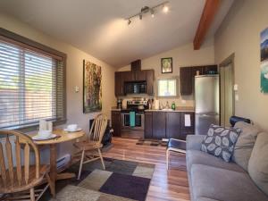 a living room with a couch and a table and a kitchen at Explorer's Retreat Sauna & Bunkhouse & Fire pit in Port Renfrew