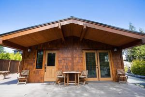 a house with a patio with a table and chairs at Explorer's Retreat Sauna & Bunkhouse & Fire pit in Port Renfrew +26 photos