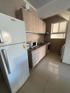 a kitchen with a white refrigerator and a microwave at Departamento temporal en Avellaneda, Santa Fe in Avellaneda