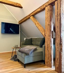 a living room with a couch and wooden beams at Dachblick by Zirwick Apartment in Windischeschenbach