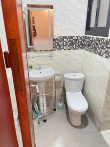 a bathroom with a toilet and a sink at Residence Life House Makepe bm in Douala +53 photos