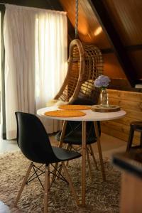a table and two chairs in a room at Recanto do Rio Chalé na Natureza in Rio dos Cedros