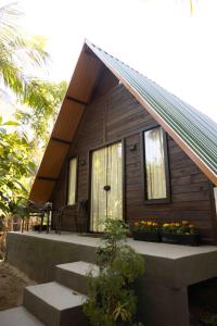 a small cabin with a porch and some flowers at Recanto do Rio Chalé na Natureza in Rio dos Cedros
