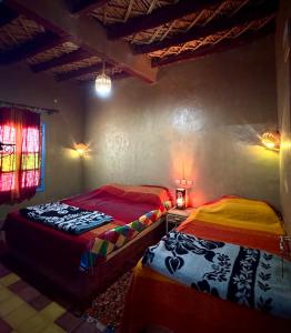 a bedroom with two beds in a room at GITE LA GROTTE VALLEE in Aoûtouss