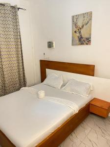 a bedroom with a bed with a wooden headboard at Residence Life House Makepe bm in Douala