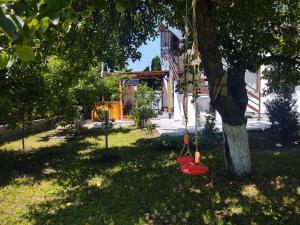 a red swing hanging from a tree in a yard at Vendel Guesthouse in Mereni