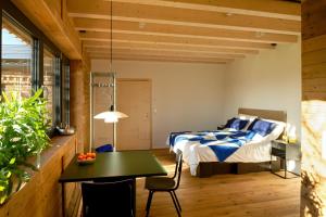 a bedroom with a bed and a table in a room at DAS SILO - Neue Ferienwohnungen und Seminarräume, eröffnet März 2026 in Fröndenberg