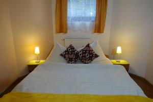 a bedroom with a large white bed with two lamps at Apartamenty u Ani in Kudowa-Zdrój