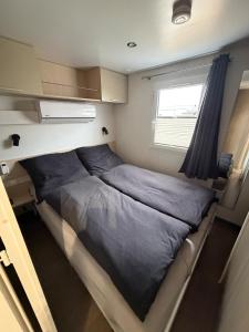 a bed in a small room with a window at Seacottage Blankenberge-Wenduine in De Haan