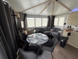 a living room with a table and chairs in a trailer at Seacottage Blankenberge-Wenduine in De Haan