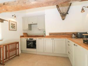 a kitchen with white cabinets and a counter top at The Forge in Stow on the Wold