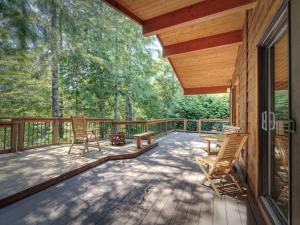 a deck with two chairs and a table on it at Hot Tub - Large Fully Enclosed deck - Pet Friendly in Port Renfrew