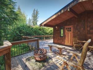 a porch of a cabin with a bench and a fire pit at Hot Tub - Large Fully Enclosed deck - Pet Friendly in Port Renfrew +9 photos