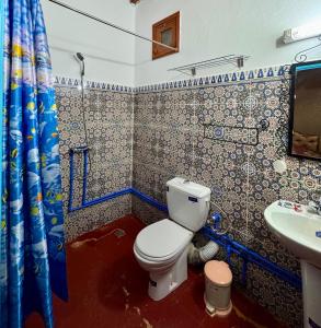 a bathroom with a toilet and a sink at GITE LA GROTTE VALLEE in Aoûtouss +43 photos