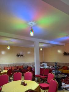 a room with tables and chairs and a rainbow on the ceiling at GITE LA GROTTE VALLEE in Aoûtouss