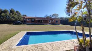 a swimming pool in front of a house at Casa 2 Silvia Beatriz in Holambra