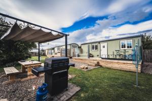 a backyard with a bbq and a house at The Swallow Shepherds Hut at Bee Happy Breaks Scotland in Perth +13 photos