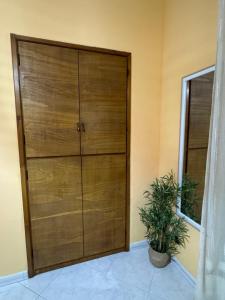 a large wooden door in a room with a plant at Il Gelso Bianco in Bordighera