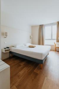 a large bed in a room with a large window at Hôtel d'Orsay Grand Matabiau in Toulouse +44 photos
