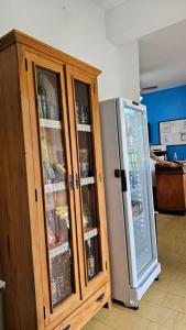 a wooden cabinet next to a refrigerator in a kitchen at Pousada Villa Real in Sabará