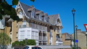 a large yellow building with a gray roof at Le Bristol in Dinard