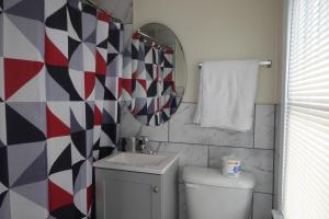 a bathroom with a toilet and a sink and a mirror at Freedom INN Motel in Grantville