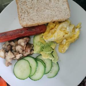 a plate of breakfast food with a sausage and vegetables at N2 Village BnB in Hadi
