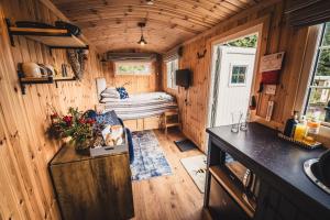 a tiny house with a kitchen and a bedroom at The Swallow Shepherds Hut at Bee Happy Breaks Scotland in Perth