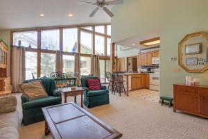 a living room with a couch and chairs and a kitchen at Lake Access w/ Dock! Hayward Cabin Hideaway in Hayward