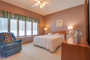 a bedroom with a bed and a chair and window at Lake Access w/ Dock! Hayward Cabin Hideaway in Hayward