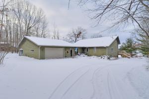 a house in the snow with a snow covered driveway at Lake Access w/ Dock! Hayward Cabin Hideaway in Hayward