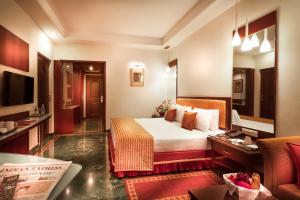 um quarto de hotel com uma cama e uma televisão em Regency Madurai by GRT Hotels em Madurai