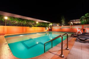 uma grande piscina à noite com luzes em Regency Madurai by GRT Hotels em Madurai