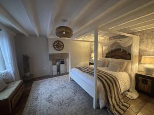 a bedroom with a canopy bed and a fireplace at Coupling Cottage in Belper