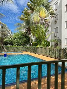 a swimming pool in front of a building at Apartamento próximo Santa Casa e ABQM in Araçatuba