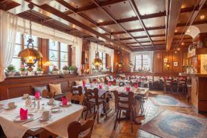 a restaurant with tables and chairs in a room at Hotel Gästehaus Hirsch in Remseck-Pattonville
