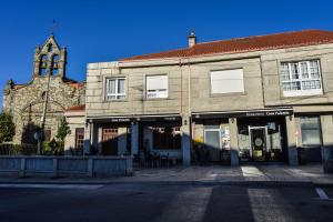 an old building with a clock tower and a church at Casa Palomin in Ourense
