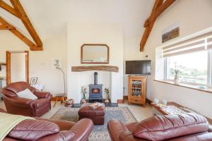 a living room with leather furniture and a fireplace at 3 Bed in Llanrwst oc-bow155 in Llanrwst