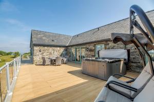 a deck with a grill and chairs on a house at 3 Bed in Llanrwst oc-bow155 in Llanrwst
