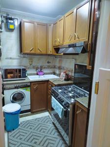 a small kitchen with wooden cabinets and a stove at Blue Wave in Alexandria
