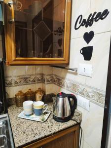 a kitchen counter with two cups and a tea kettle at Blue Wave in Alexandria