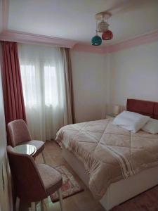 a bedroom with a bed and a chair and a window at Blue Wave in Alexandria +4 photos