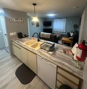a kitchen counter with a sink and a living room at Homestake Haven in Lead
