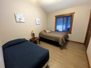 ein Schlafzimmer mit einem Bett und einem Fenster in der Unterkunft Wolf Den in Valemount