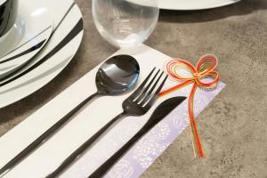 a fork and spoon with a ribbon on a table at なんばや心斎橋にも直結の最大8名宿泊可能の広々メゾネット JPtrad 桔梗 in Osaka